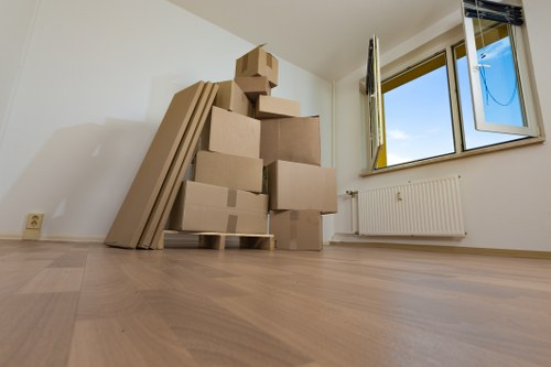 Professional movers carrying furniture from a flat with stair access in Palmers Green